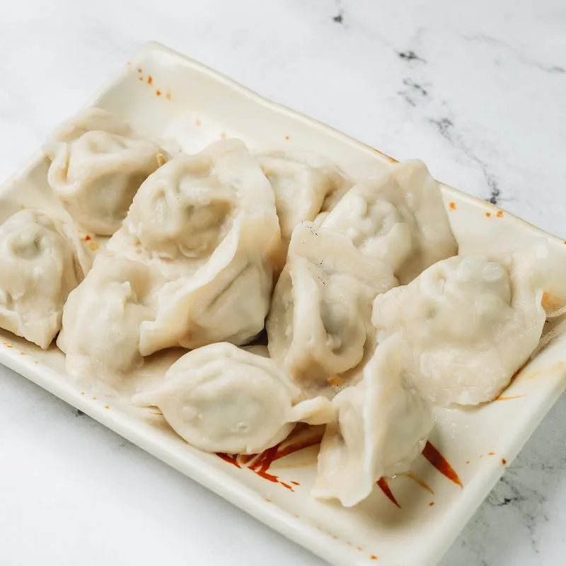 Steamed dumplings served on a rectangular white plate